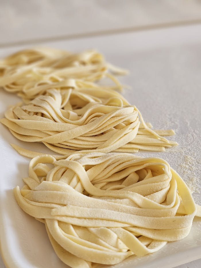 Close-up of freshly made pasta sheets on a kitchen table, ready for cooking.