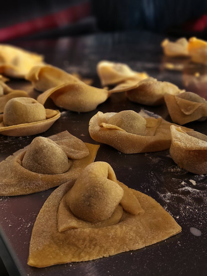 Close-up of raw handmade tortellini ready for cooking, showcasing texture and craftsmanship.