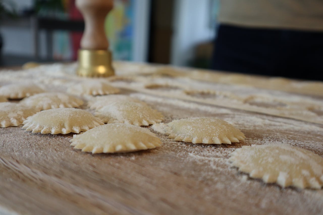 Close-up of uncooked ravioli on a floured board, ready for cooking.